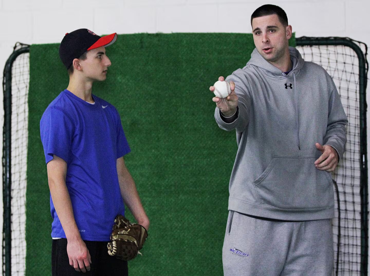 Coach Jeff Allison teaching grip and throwing to a young player